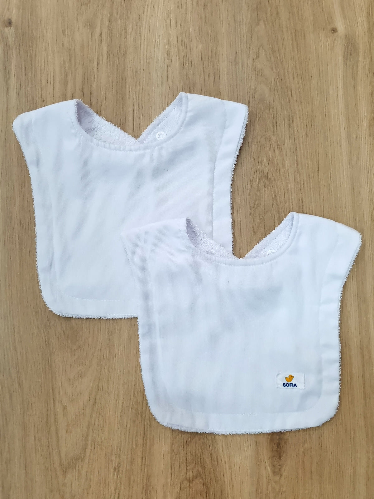 Set de 2 baberos. Blancos