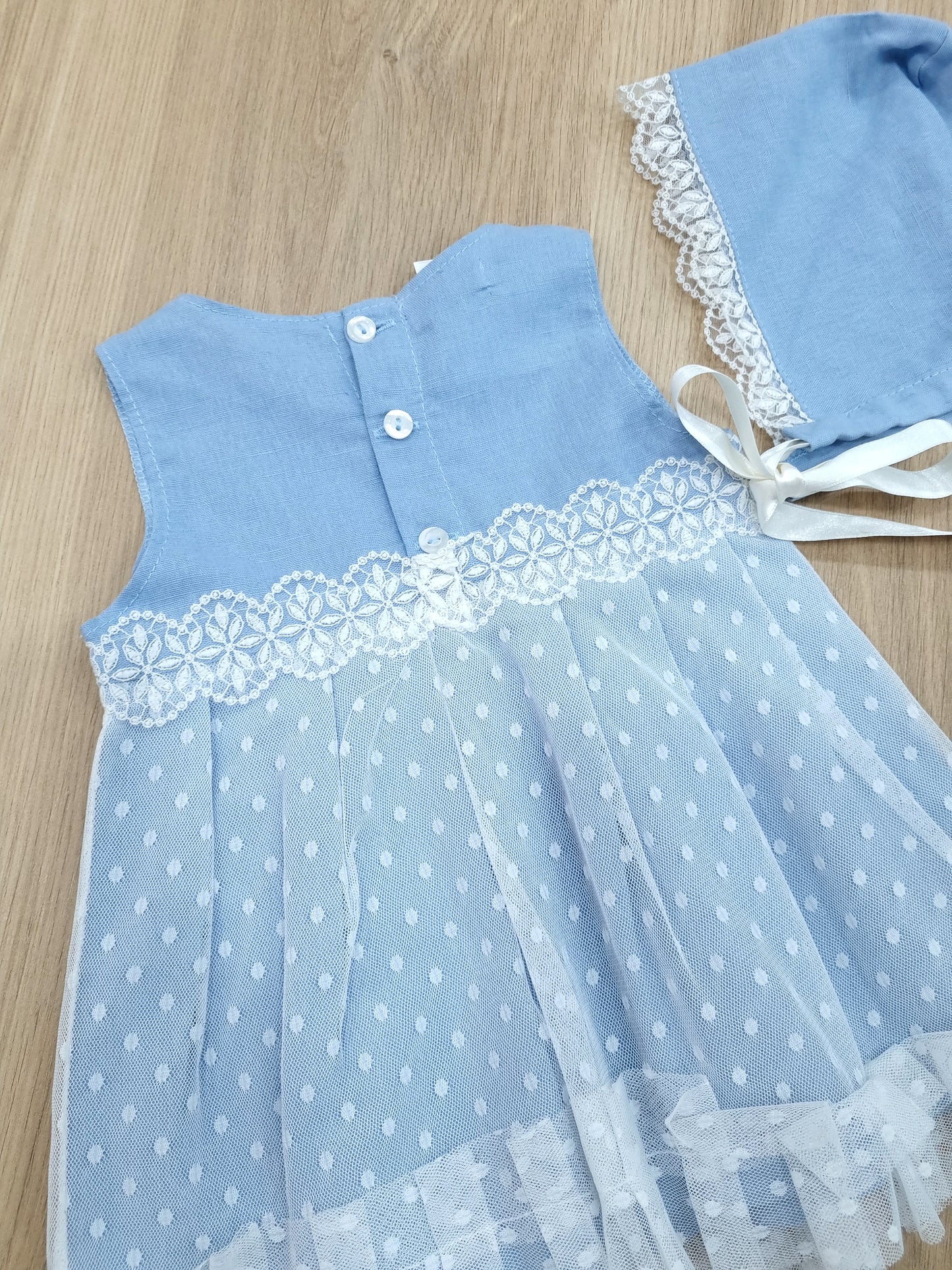 Vestido Celeste, con encaje blanco en falda, incluye gorro. 3M
